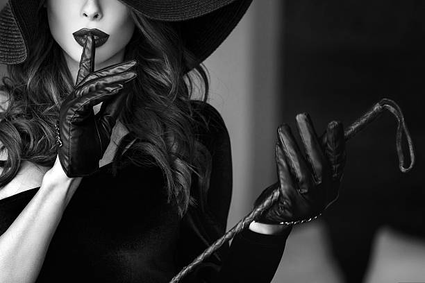 Woman in hat and whip showing no talk Woman in hat and whip showing no talk, black and white dominatrix stock pictures, royalty-free photos & images