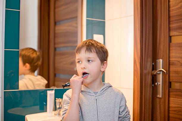 istock 7 years old boy brushing his teeth in the bathroom 515234626