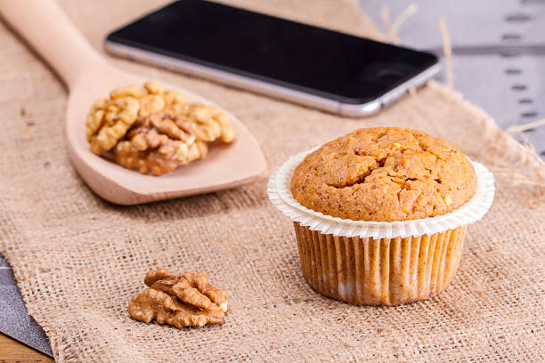 appena sfornato la torta in un piatto in iuta con cellulare - muffin blueberry muffin blueberry isolated foto e immagini stock