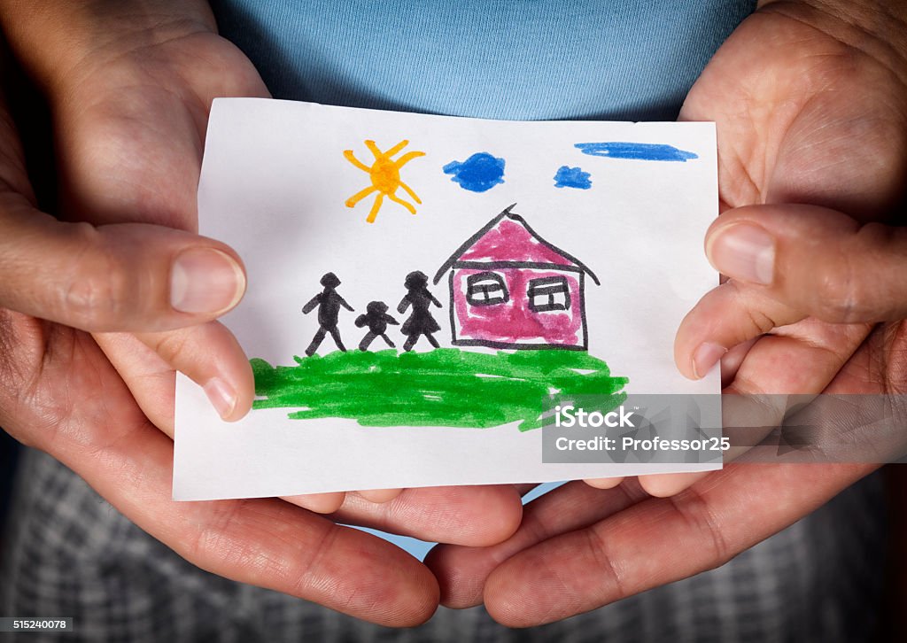 Child and his mom holding a drawn house with family Child and his mom holding a drawn house with family. Close up. Vignette. Adoption Stock Photo