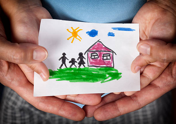 Child and his mom holding a drawn house with family Child and his mom holding a drawn house with family. Close up. Vignette. adoption stock pictures, royalty-free photos & images