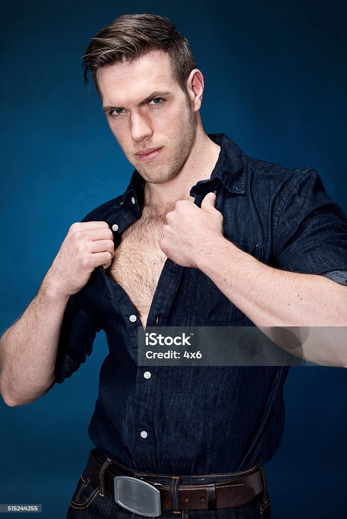 Muscular man in front of blue background Muscular man in front of blue backgroundhttp://www.twodozendesign.info/i/1.png 20-29 Years Stock Photo