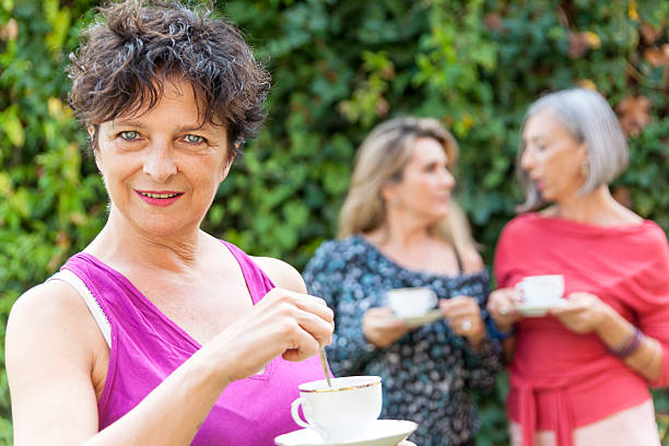istock lady drinking a cup of tea with friends 515246325