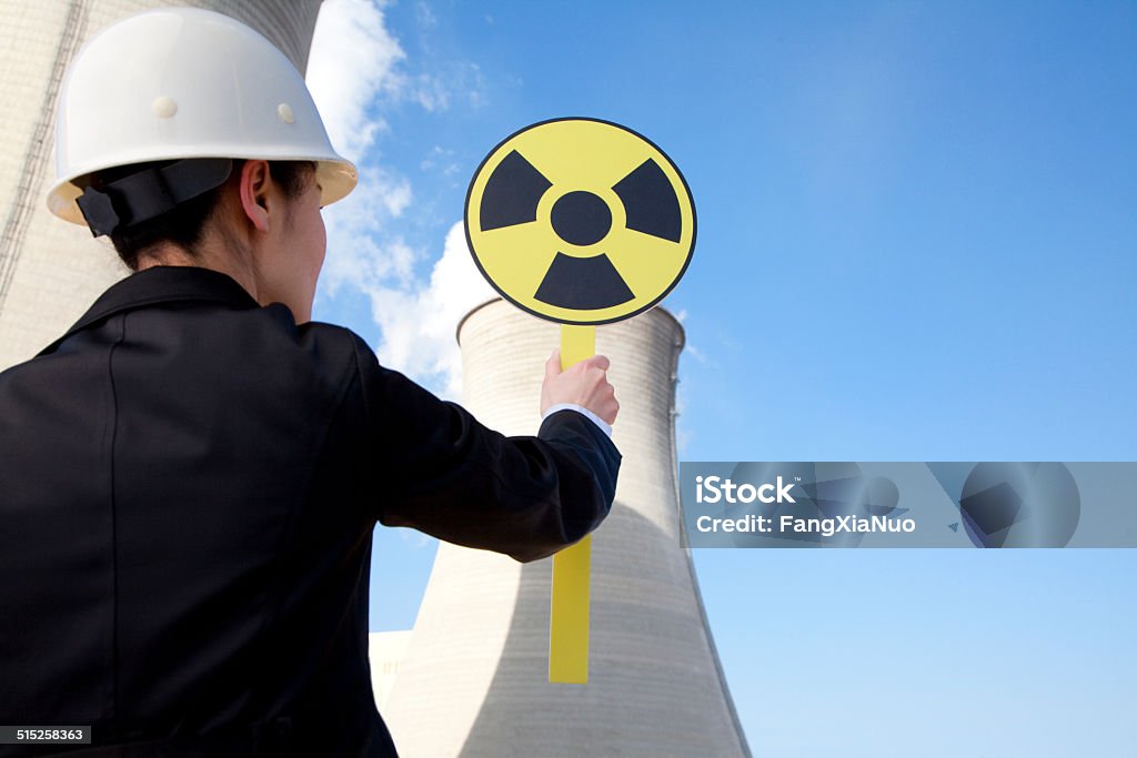 Engineer in front of cooling towers with sign 20-24 Years Stock Photo