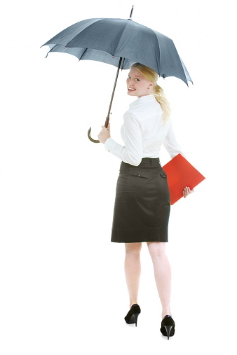 Happy businesswoman under open umbrella stretching her arm