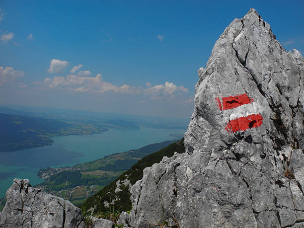 mountain view with Austrian flag view on lake Attersee (Austria) with the Austrian flag symbolizing the hiking trail attersee stock pictures, royalty-free photos & images