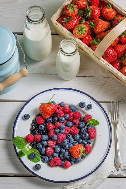 frische beeren früchte mit milch - berry fruit refreshment rural scene vertical stock-fotos und bilder