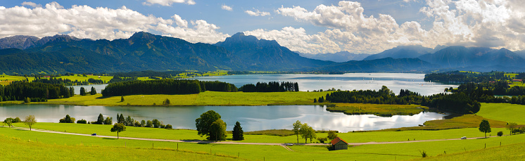 rural panorama landscape with lake Forggensee and alps mountains in Bavaria, Germany, nearby city Fuessen