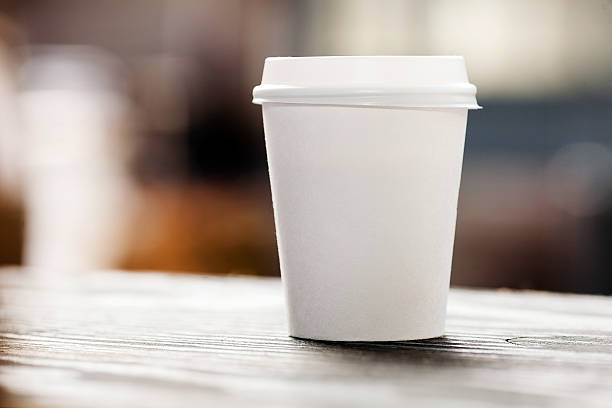 descartável xícara de café em windowsill com vista da cidade no fundo - take out food nobody disposable cup coffee - fotografias e filmes do acervo