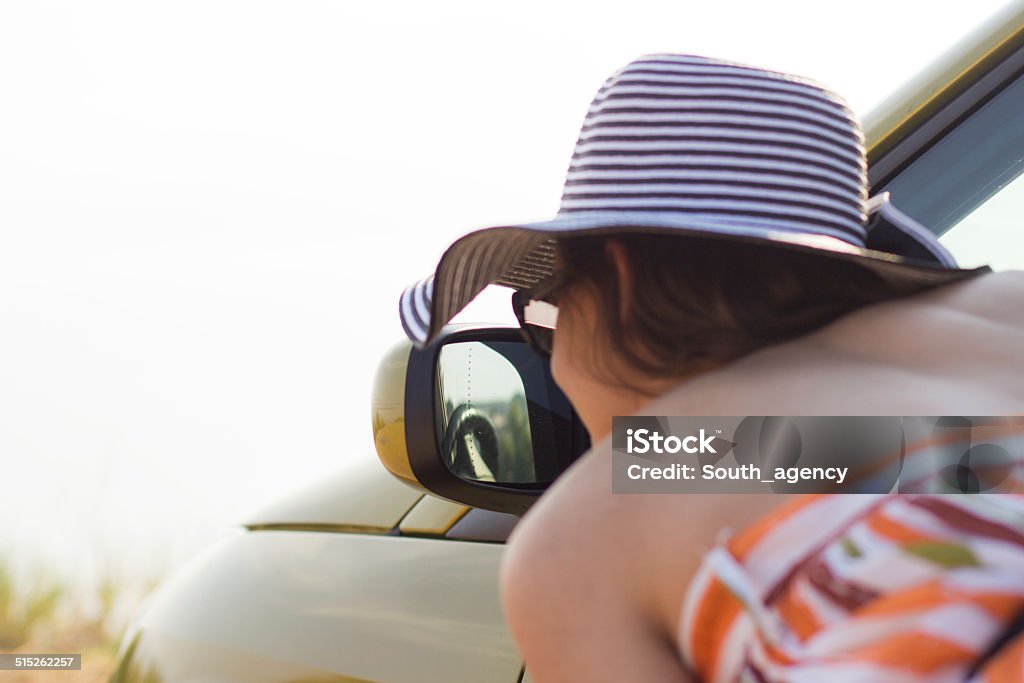 Looking at the rear-view mirror Looking at the rear-view mirror. Adolescence Stock Photo