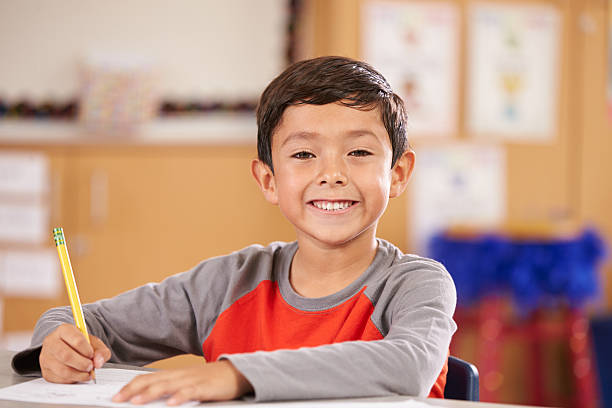 istock Portrait of a boy at elementary school sitting in classroom 515262264