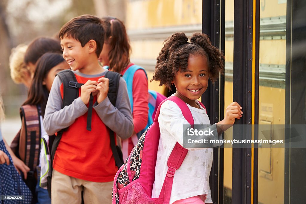 Escuela primaria chica en la parte frontal de la cola autobús escolar - Foto de stock de Niño libre de derechos