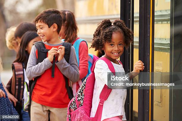 Escuela Primaria Chica En La Parte Frontal De La Cola Autobús Escolar Foto de stock y más banco de imágenes de Niño