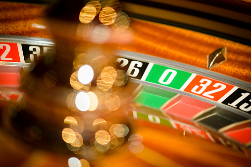 Close up shot of a roulette wheel in a casino. Focus on the number 0.