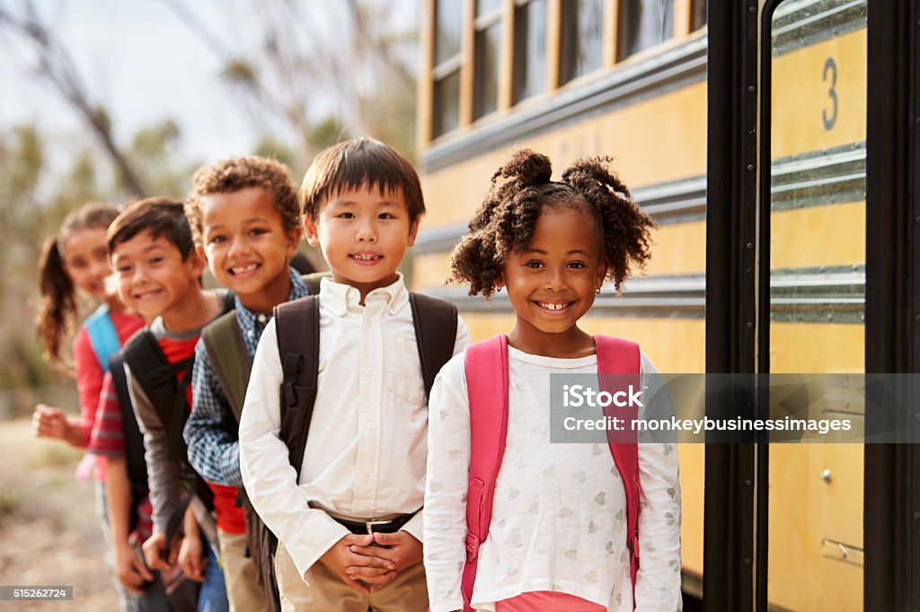 Elementary school kids queueing to get on to a school bus Child Stock Photo