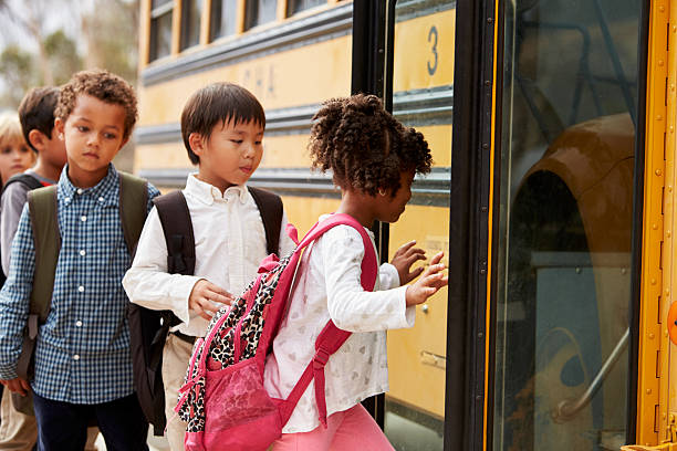 istock Elementary school kids climbing on to a school bus 515262746