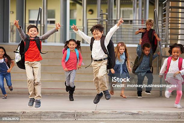 Eine Gruppe Dynamischer Grundschule Kinder Verlassen Der Schule Stockfoto und mehr Bilder von Abschied