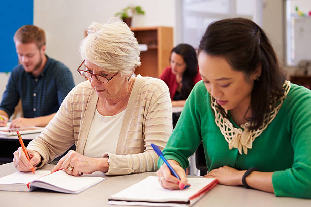 istock Two women sharing a desk at an adult education class 515263556