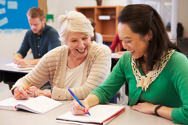 istock Teacher and student sit together at an adult education class 515263638