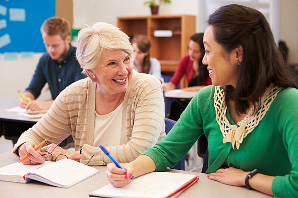 istock Teacher and student sit together at an adult education class 515263684