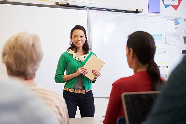 istock Teacher with tablet and students at an adult education class 515263812