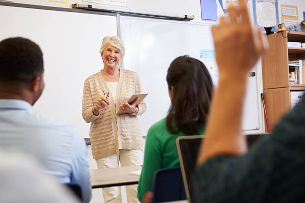 istock Teacher with tablet and students at an adult education class 515263888