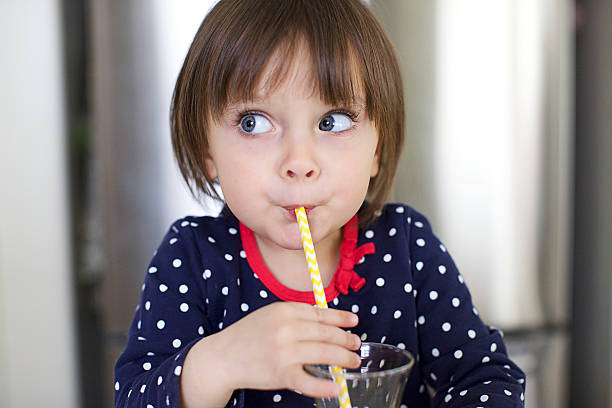 istock Little Girl Drinking With a Straw and Making Faces 515263947