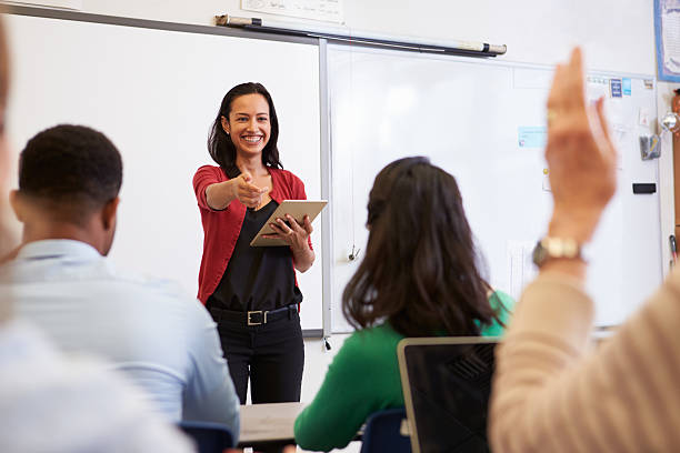 enseignant avec tablette et les élèves en classe de l'éducation des adultes - teaching photos et images de collection