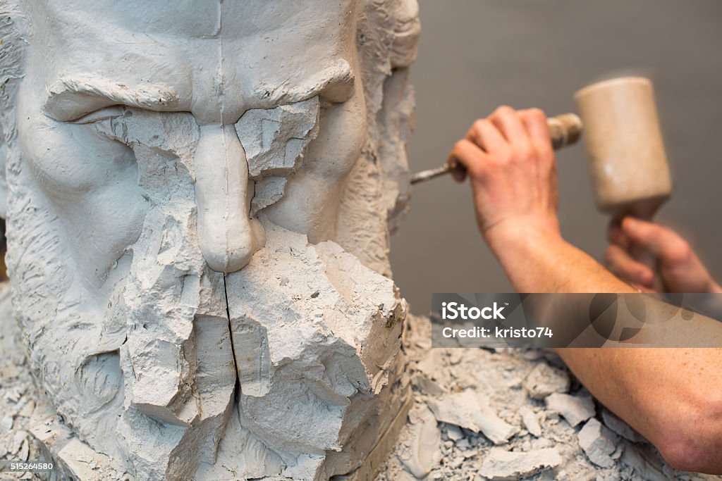 Positive Negative Form. Hands of sculptor and hammer detail while carving. Sculptor Stock Photo
