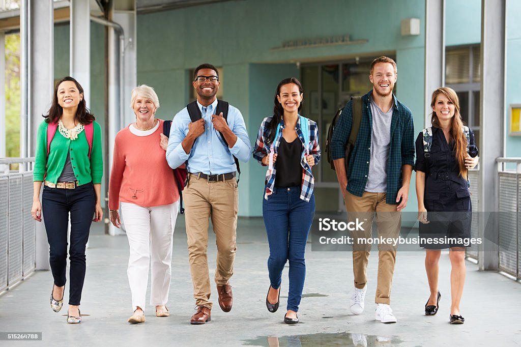 A group of happy teachers walking in a school corridor Arrival Stock Photo