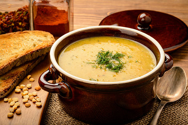 Pea cream soup in brown ceramic pot.