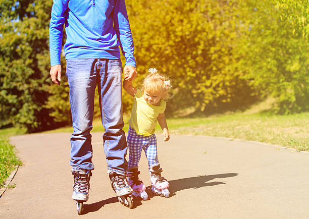 istock father teaching little daugther to roller skate in summer 515267204