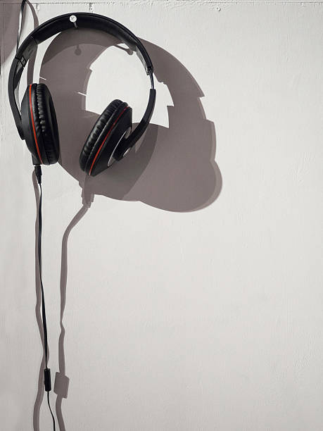 istock black headphones hanging on a white wall 515267528