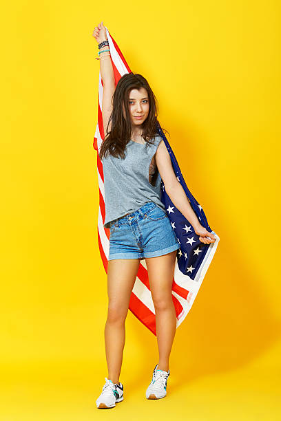 istock young woman holding american flag 515268474