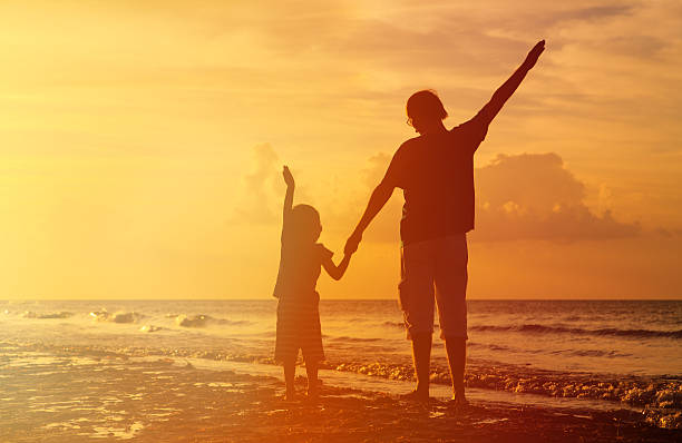 istock father and son silhouettes play at sunset 515270470