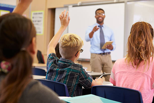 istock Kids raising hands to answer in an elementary school class 515271086