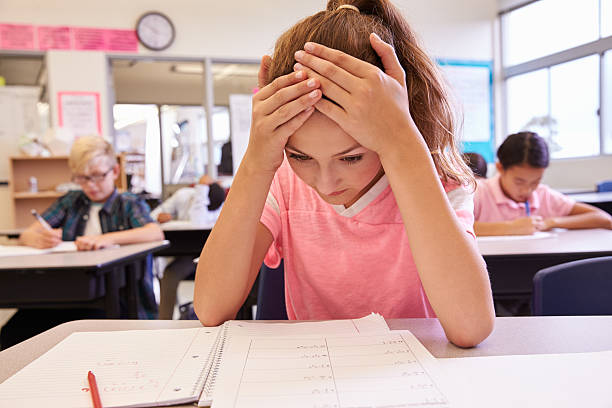 istock Schoolgirl with head in hands in an elementary school class 515271826