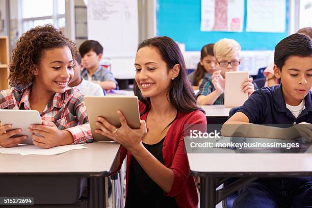 Teacher Helping Kids With Computers In Elementary School Stock Photo - Download Image Now