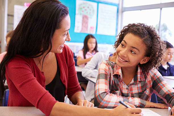 istock Teacher working with elementary school girl at her desk 515273210