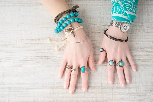 Photo of Hands of women in the jewelry of turquoise
