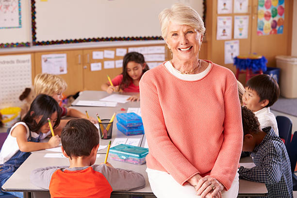 istock Senior teacher in classroom with elementary school kids 515274070