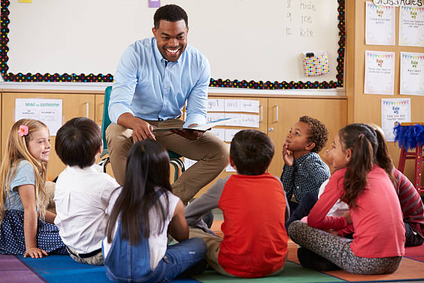 istock Elementary school kids sitting around teacher in a classroom 515274392