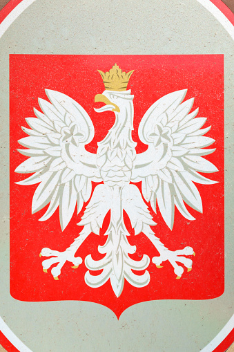Photo of the Polish coat of arms, as seen on a public building in Warsaw, Poland. It is an image of a crowned white eagle in a red field.