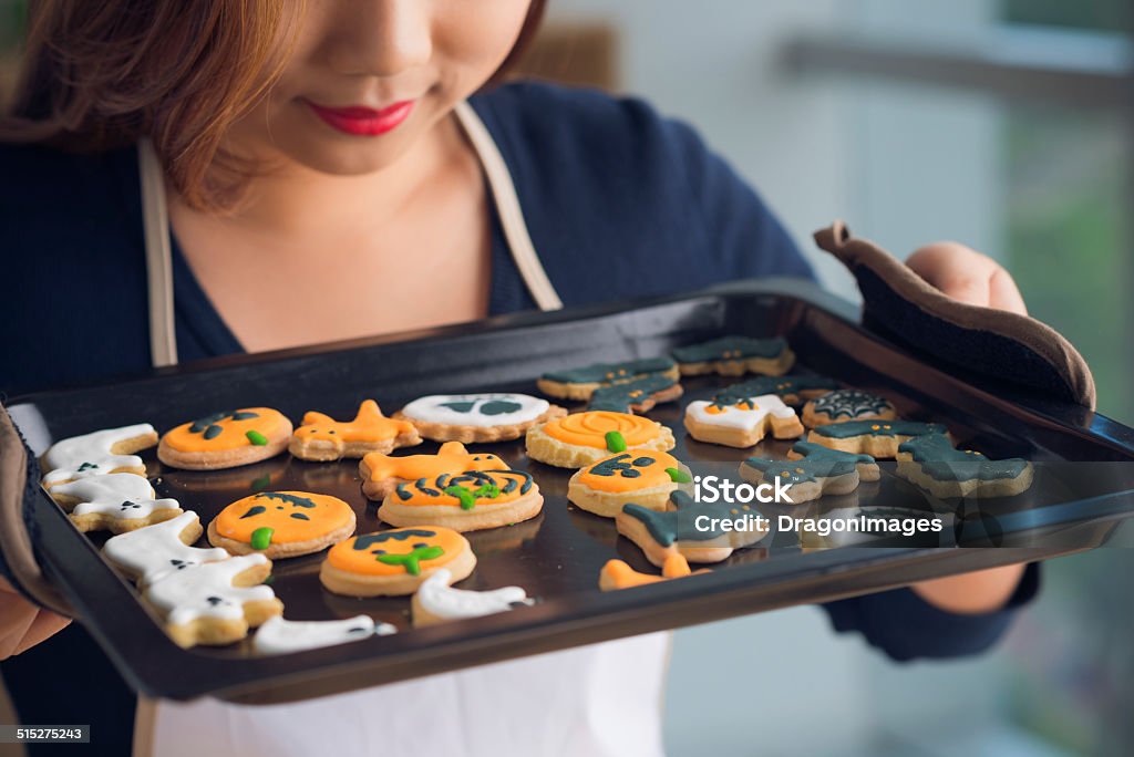 Tray with cookies Cropped image of housewife enjoying the smell of Halloween cookies on the tray Adult Stock Photo