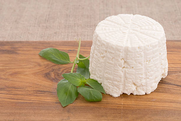 Ricotta cheese, fresh from the mould, mold with basil. Farm produced. ricotta stock pictures, royalty-free photos & images