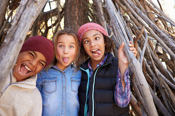 group of children playing in forest camp together - een gek gezicht trekken stockfoto's en -beelden