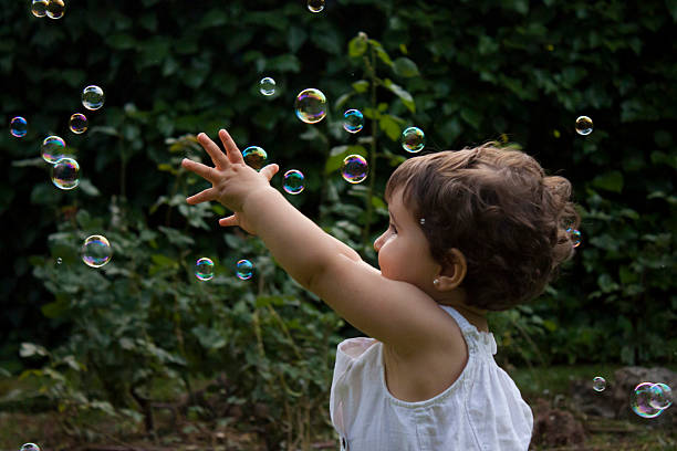istock Girl playing with soap bubbles in the garden 515306744