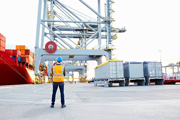 Foreman control loading container by crane at international container sea port.