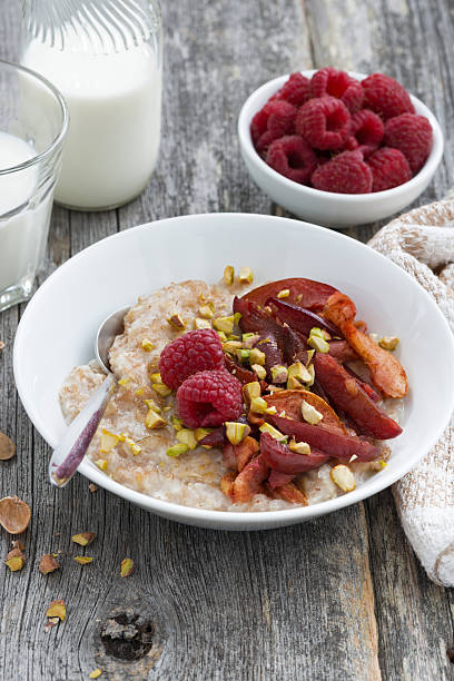 istock oatmeal with baked fruit and pistachios for breakfast, vertical 515307056
