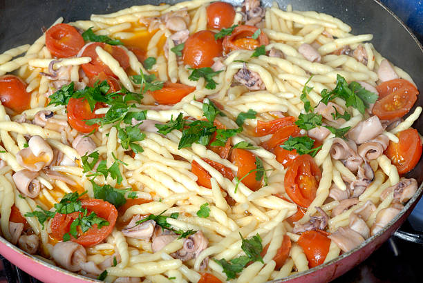 Trofie com Chocos com tomate e salsa - fotografia de stock